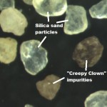 Here is a microscopic picture of nice silica sand particles next to some impurities and non-silica particles.